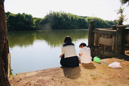 水辺で後ろ姿の女子高校生と男の子を撮影するロケ風景